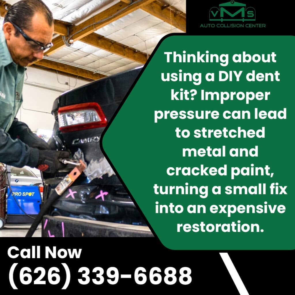 Technician repairing a dent on a black vehicle at VMS Auto Collision Center to prevent paint damage and restore the panel correctly