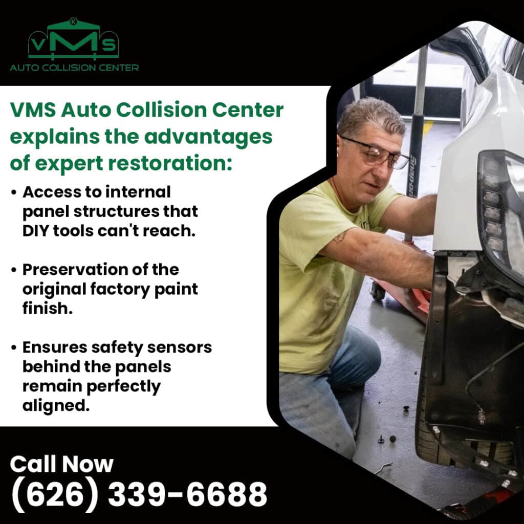 Auto body technician performing professional panel restoration on a white vehicle at VMS Auto Collision Center
